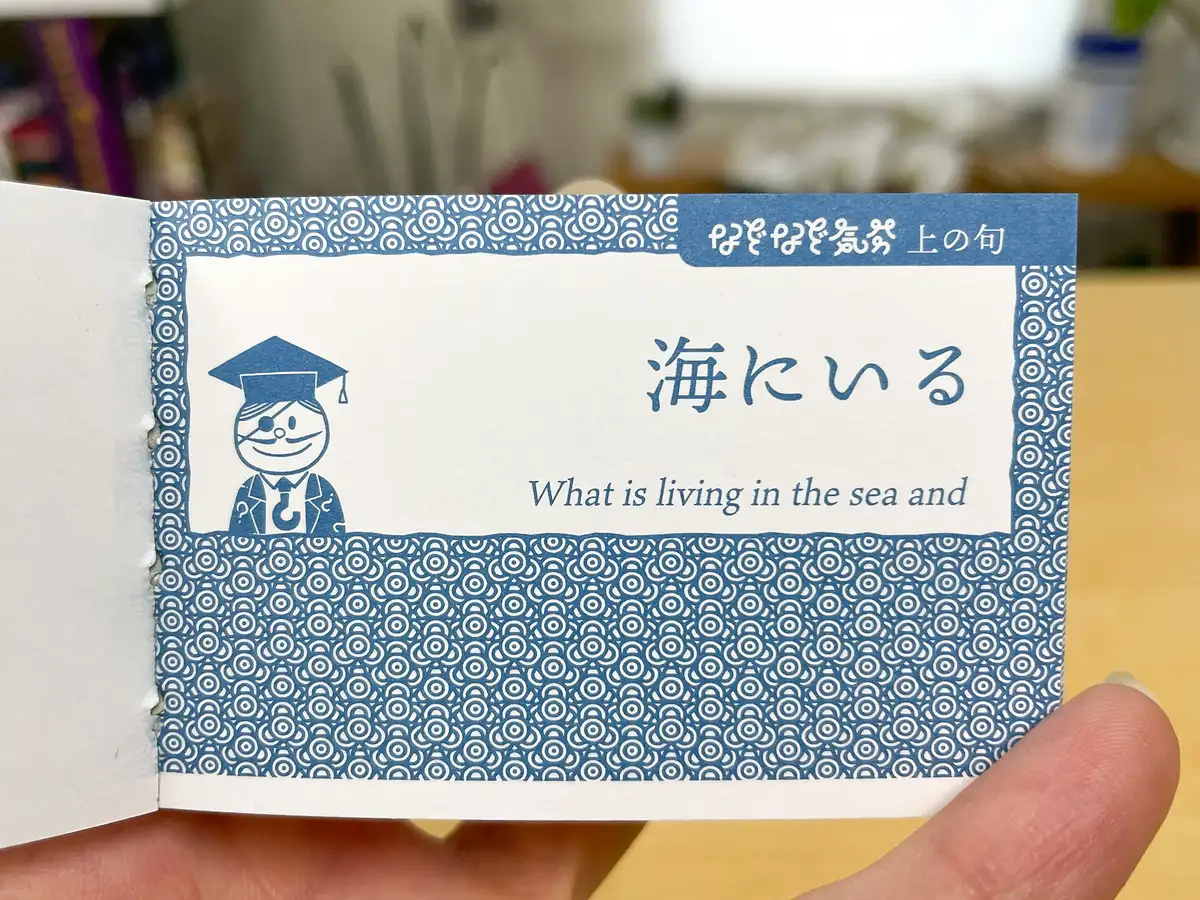 『なぞなぞ気分・青本』をやってみましょう。上の句をペラペラ‥‥。「海にいる」になりました