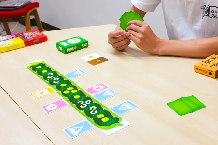 ▲得点になる「お豆(プラス)」や「虫くん(マイナス)」のカード越しに、数字カードを出していく